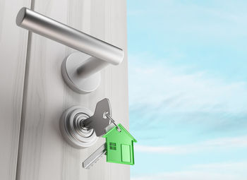 Low angle view of key hanging on door against sky