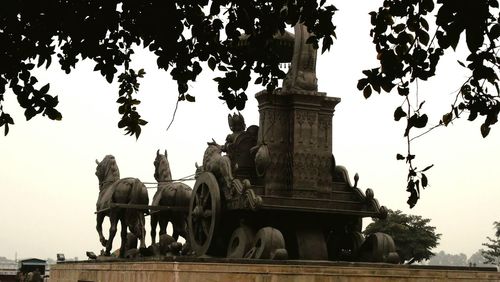 Low angle view of statues against sky