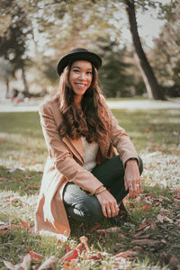 Portrait of smiling young woman sitting on field