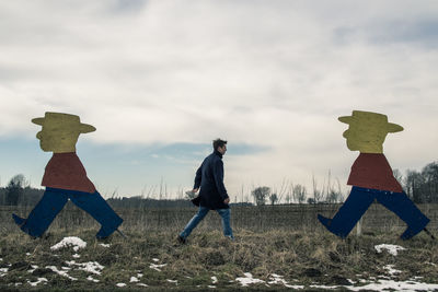 Men standing on field against sky