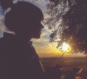 Rear view of girl standing by tree