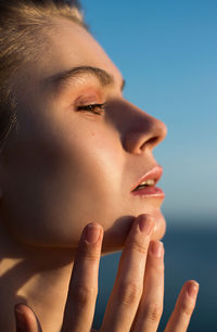 Close-up of beautiful woman standing against sky