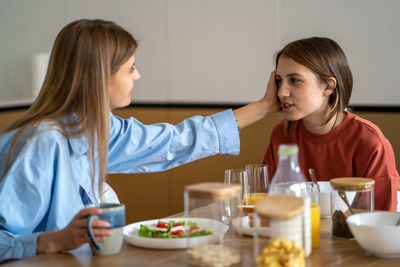 Portrait of young woman having food at home