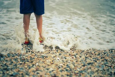 Low section of woman standing on beach