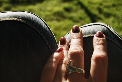 Cropped hand of woman touching seat outdoors