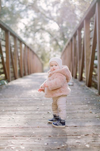 Baby standing on a bridge and looking at camera