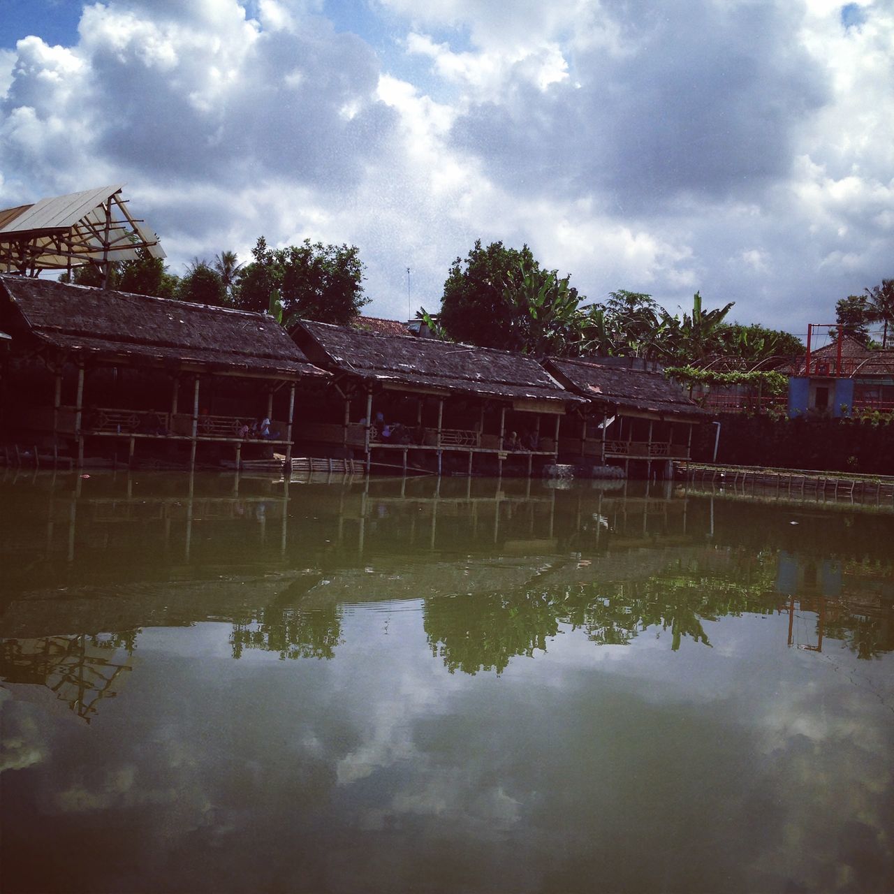 water, built structure, sky, architecture, reflection, cloud - sky, waterfront, building exterior, cloudy, lake, cloud, river, bridge - man made structure, tree, nature, day, connection, outdoors, no people, tranquility