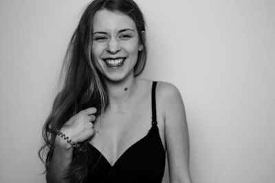 Cheerful young woman standing against white background