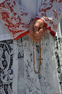 Midsection of priest standing with rosary beads