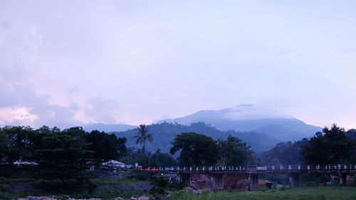 Scenic view of trees and mountains against sky