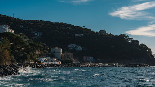 Scenic view of sea and cityscape against sky