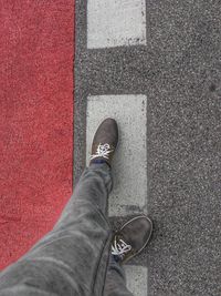 Low section of man standing on road