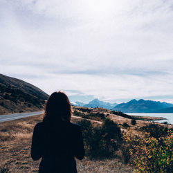 Rear view of woman standing on mountain