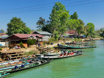 Boats moored in river against sky