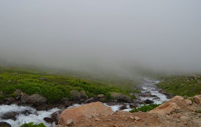 Scenic view of landscape against sky during foggy weather