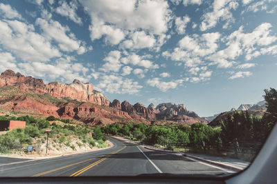 Road leading towards mountains against sky