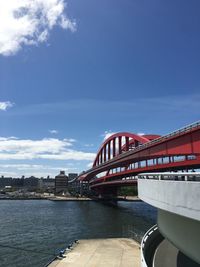 Bridge over river against cloudy sky