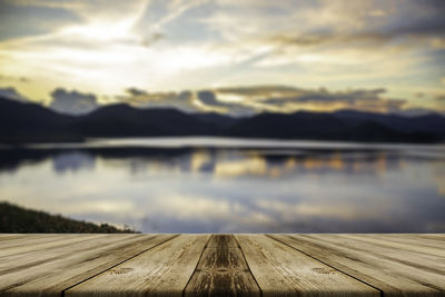 Pier over lake against sky during sunset