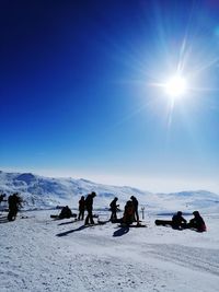 People on snowcapped mountain against sky