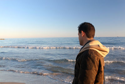 Rear view of a man standing on beach