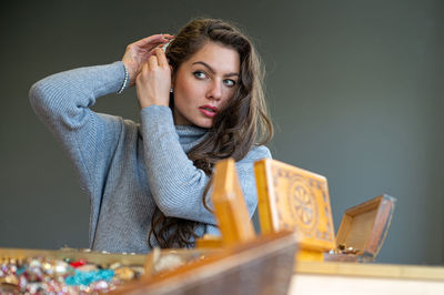 Portrait of young woman holding hands on table