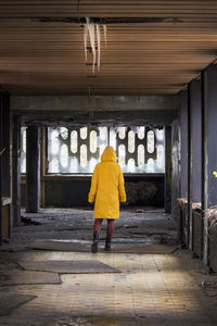 Rear view of woman walking in tunnel