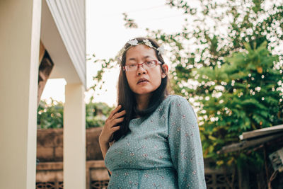 Portrait of mid adult man standing against trees