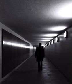 Rear view of woman walking in tunnel