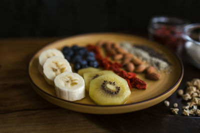 Healthy breakfast plate of fruit, berries and seeds with yogurt and granola