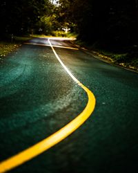 Close-up of road against trees at night
