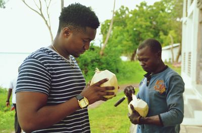 Friends holding coconuts outdoors