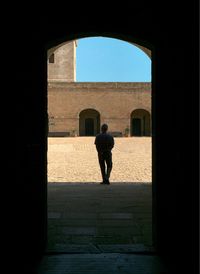 Full length of silhouette man in corridor against sky