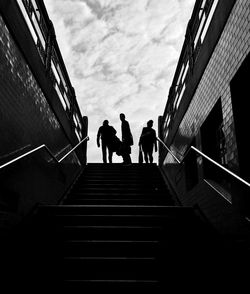 Silhouette people seen through subway against sky