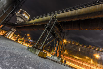 Low angle view of illuminated bridge against sky at night