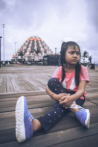 Full length of woman sitting against sky