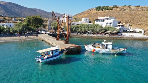 Sailboats moored on sea by city