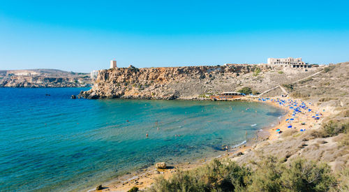 Scenic view of beach against clear blue sky