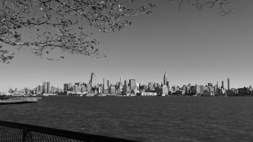 River and urban skyline against clear sky