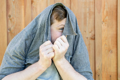 Portrait of young man lying on wood