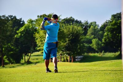 Full length rear view of man standing on golf course