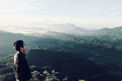 Man standing on mountain against sky