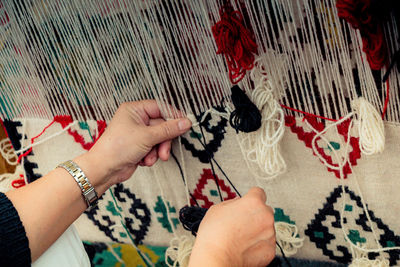 Cropped hand of woman working with wool indoors