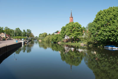 Panoramic view of lake amidst trees and buildings against sky