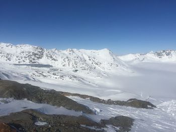 Scenic view of snowcapped mountains against clear blue sky