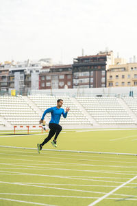 Side view of man running on grassland