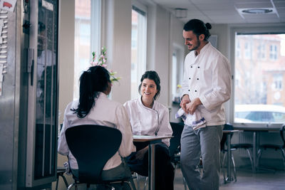 Male and female chefs discussing menu in restaurant