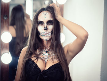 Close-up portrait of young woman with spooky face paint