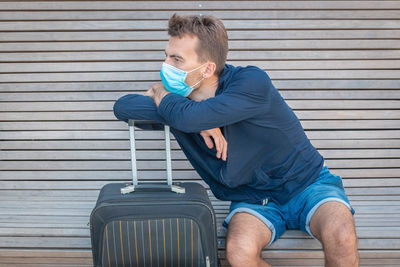 Side view of man sitting on bench