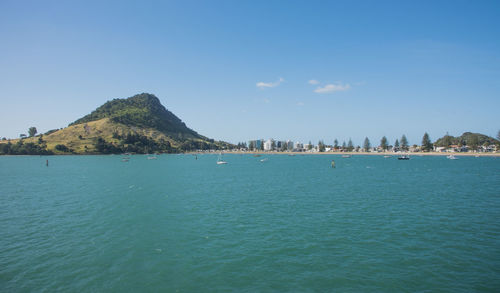 Scenic view of sea and mountains against blue sky