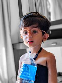 Portrait of cute girl wearing eyeglasses holding water bottle